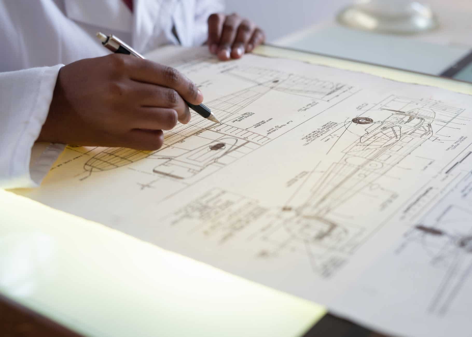 faceless engineer adding details to sketch of aircraft