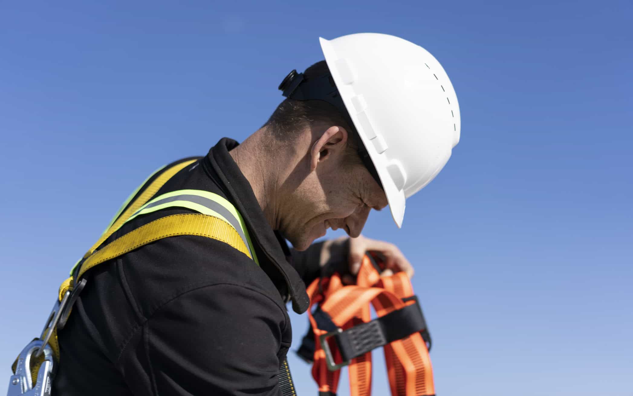 Worker addressing fall protection equipment