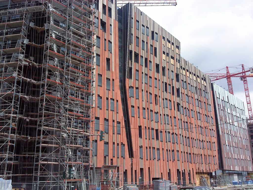 Cranes Against Red Building