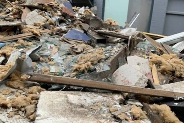 Significant amounts of asbestos-containing debris to the front and rear of the building and along the public highway