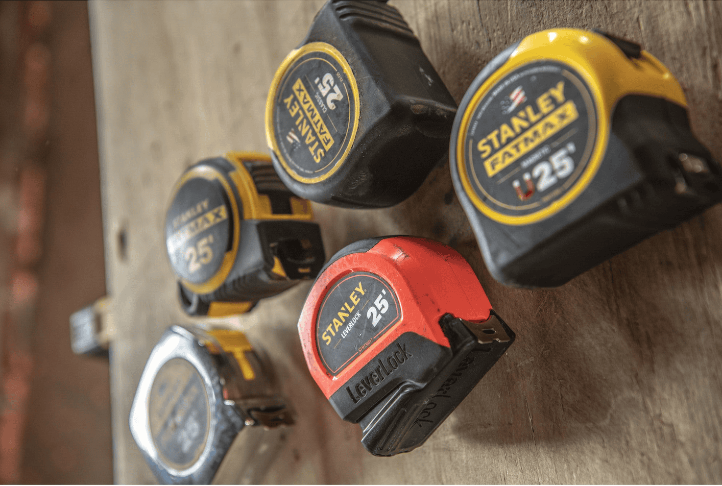 Stanley tape measures on a wooden table.